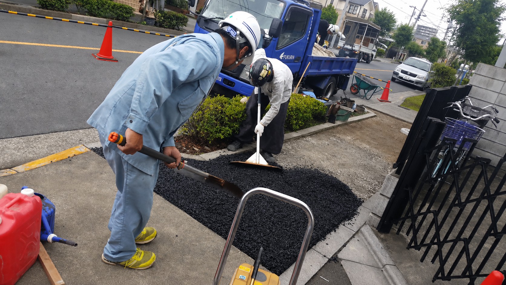 福鈴巧建の作業員がアスファルト舗装を施工している現場
